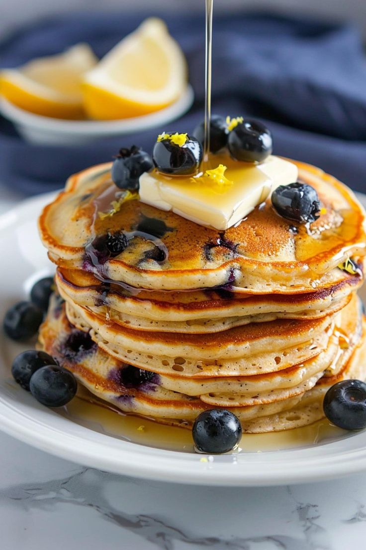 a stack of pancakes with blueberries and butter on top