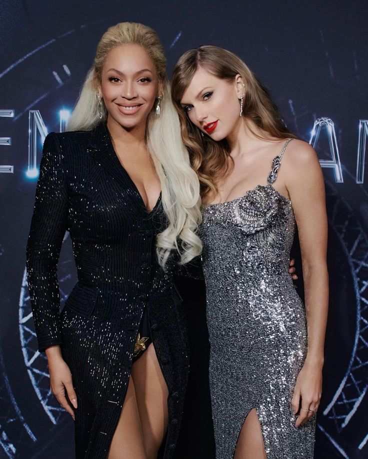 two women standing next to each other on a red carpet