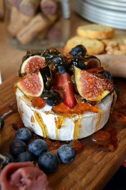 a cheese dish with figs and blueberries on it