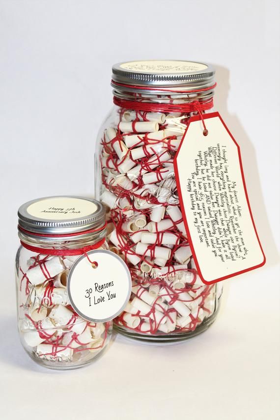 a jar filled with white and red candy canes next to a tag that says, i love you