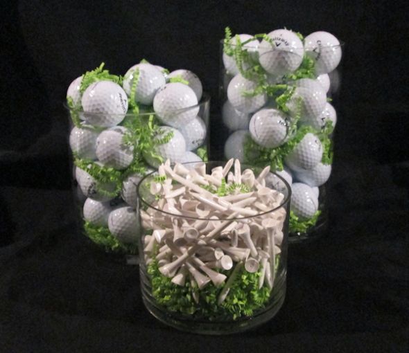 some golf balls and greens in a glass vase