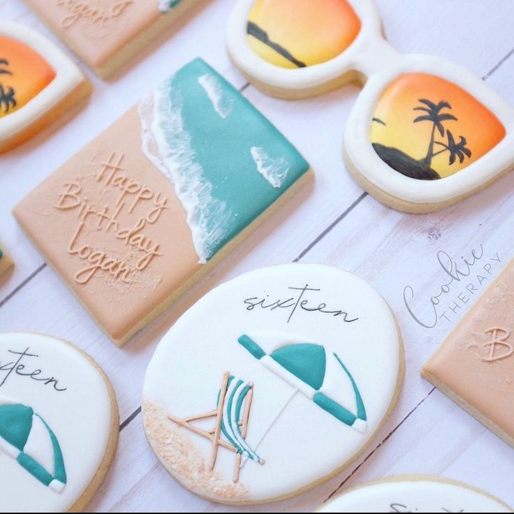 decorated cookies are arranged on a table with the words happy birthday written on them and beach scenes