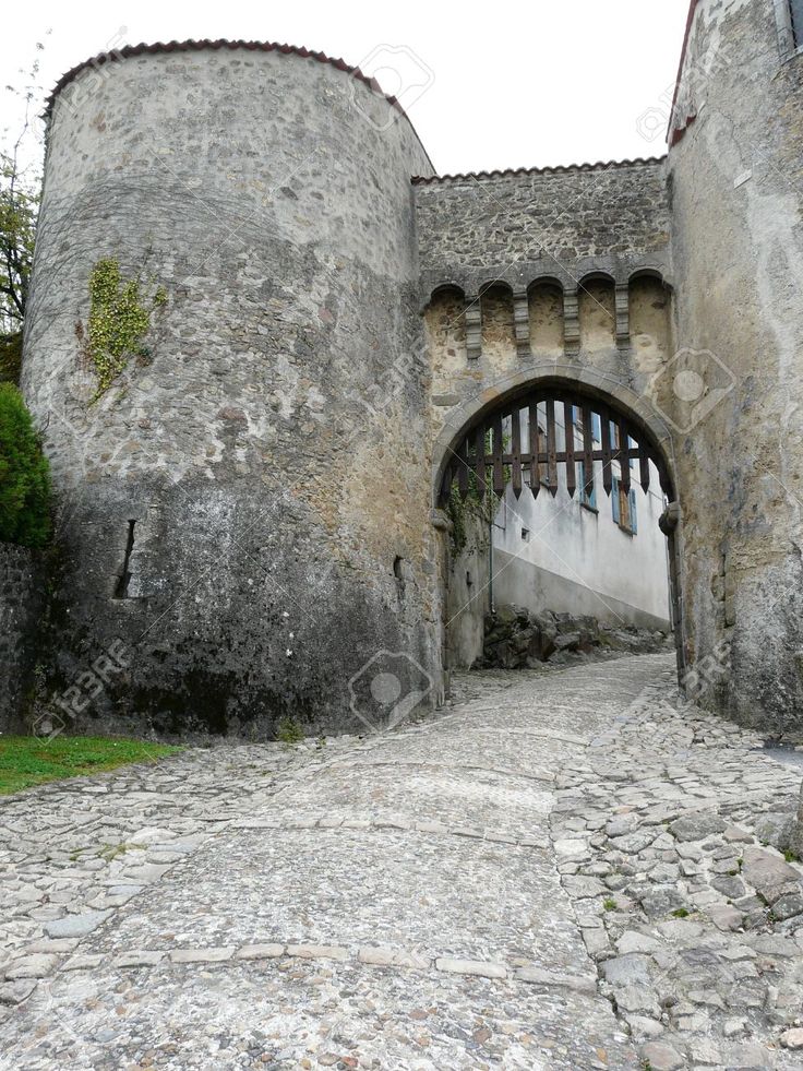 an old stone building with a gate in the middle