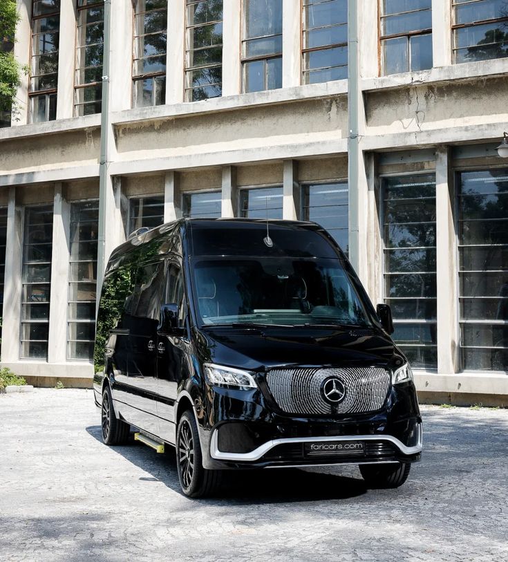 a black mercedes van parked in front of a building