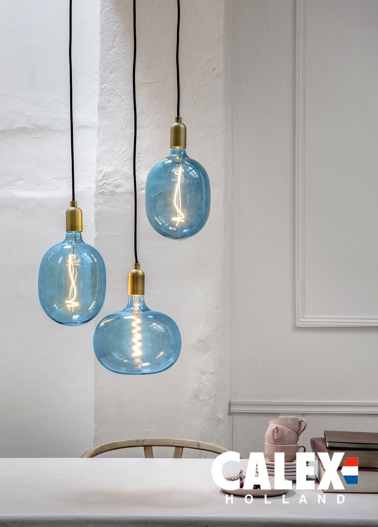 three light bulbs hanging from the ceiling above a table with books and a teddy bear