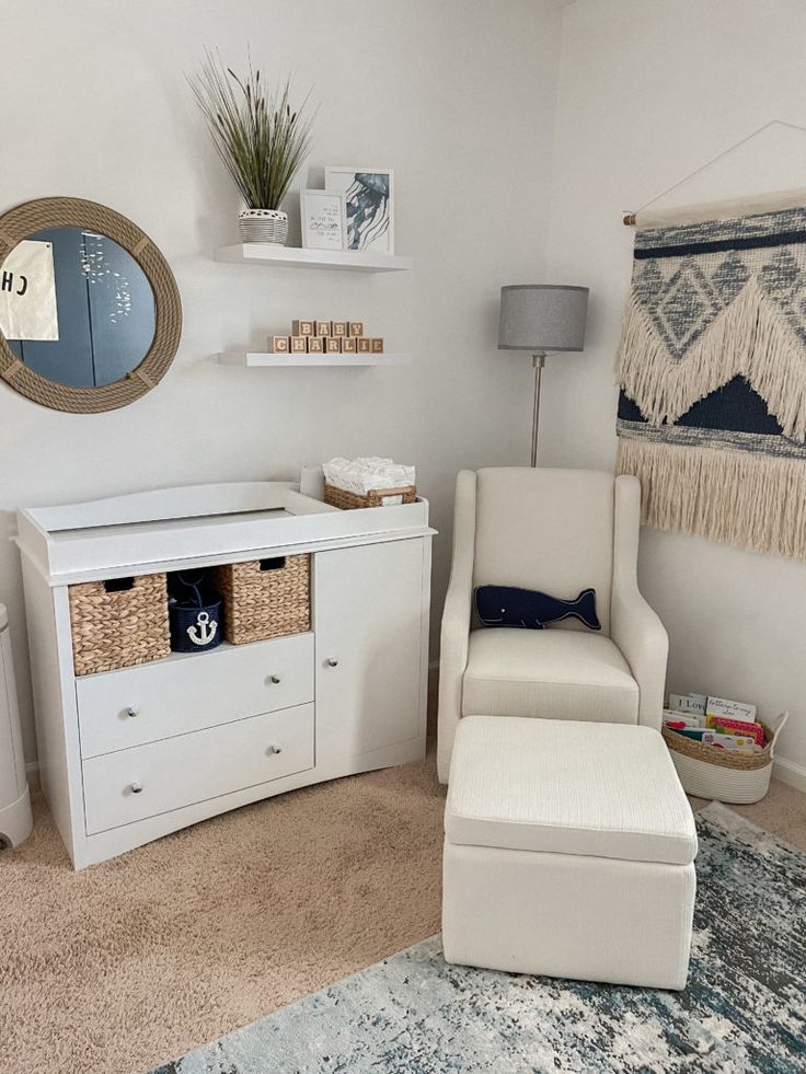 a white chair sitting next to a dresser in a room with a rug on the floor