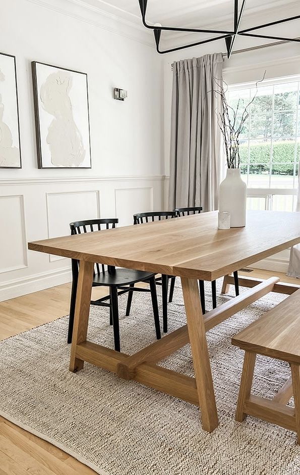 a dining room table and benches in front of a window