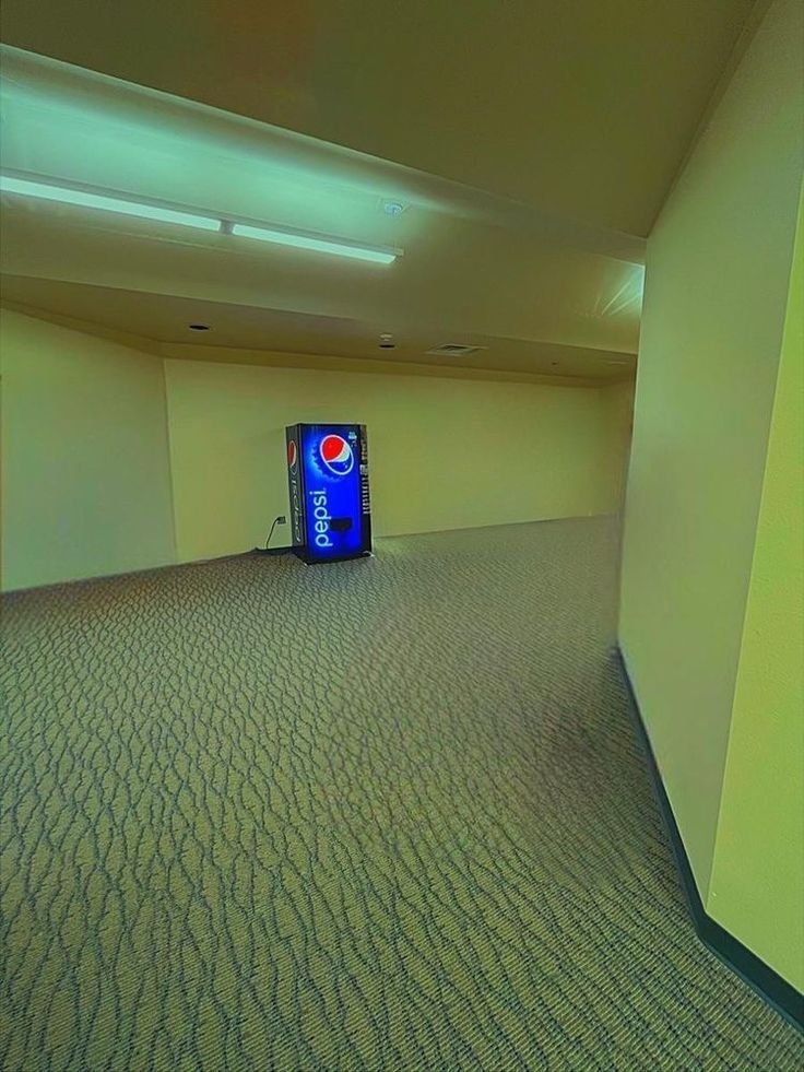 an empty room with a television in the corner and a pepsi can on the floor