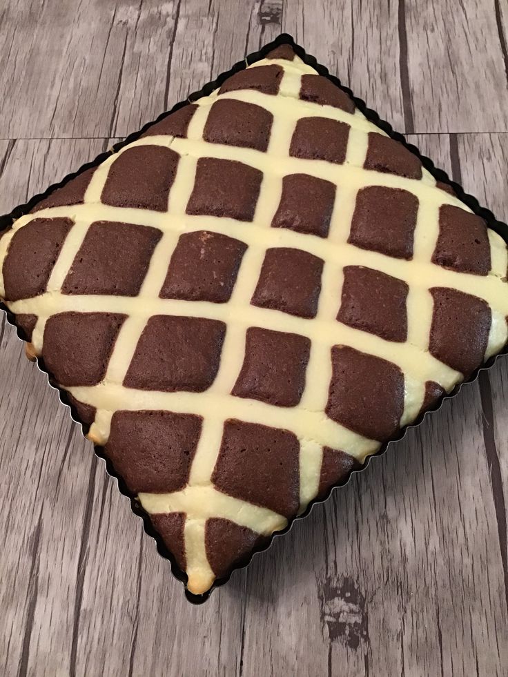 a chocolate cake with white icing sitting on top of a wooden table