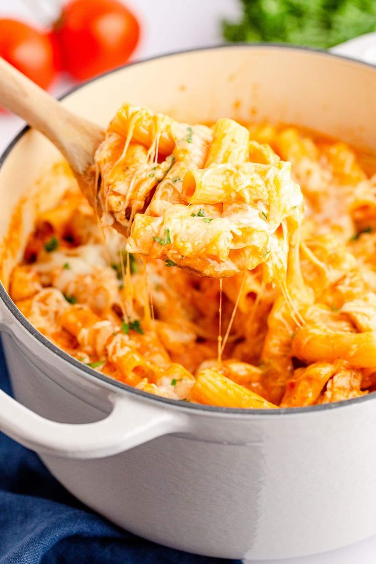 a wooden spoon scooping out some pasta from a pot