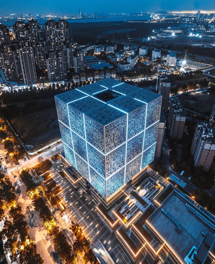 an aerial view of a large building in the middle of a city at night time