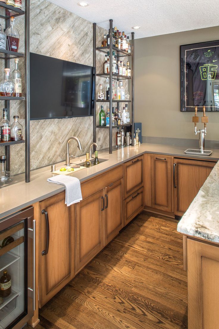 a kitchen with wooden cabinets and marble counter tops is shown in this image, there are wine bottles on the shelves