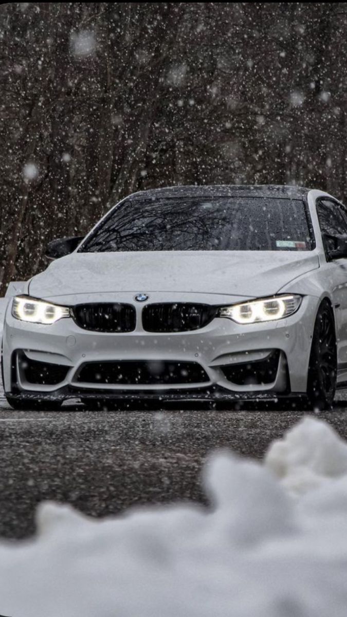 a white car driving down a snow covered road