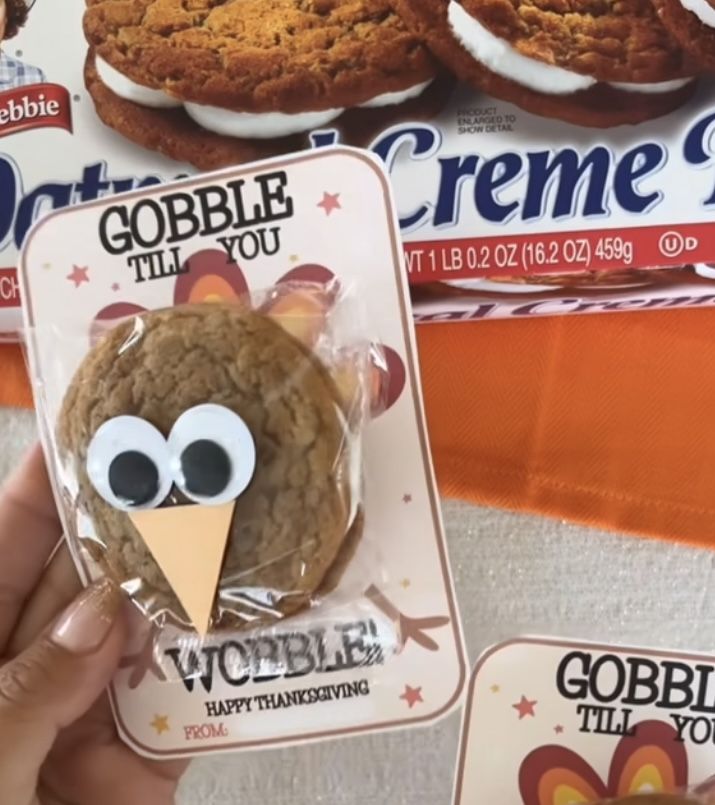 someone is holding up a cookie that looks like an owl in front of some cookies