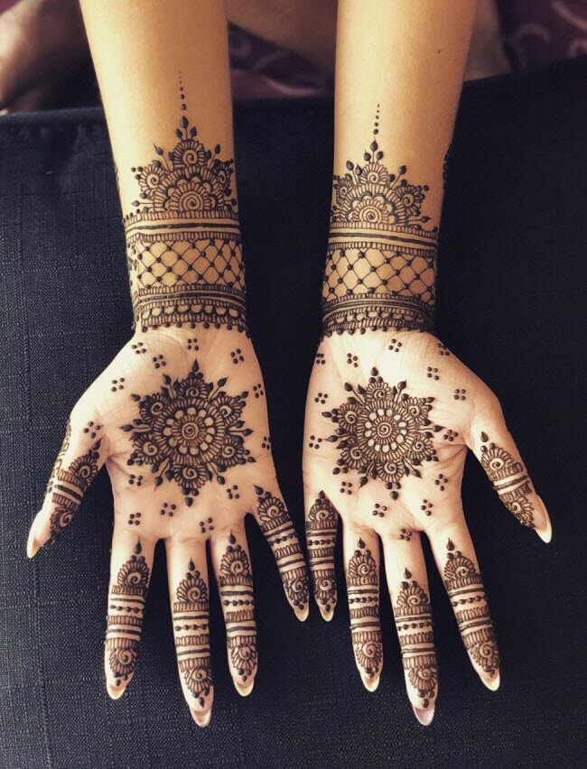 two hands with henna tattoos on them