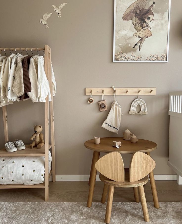 a baby's room with a wooden table and chair