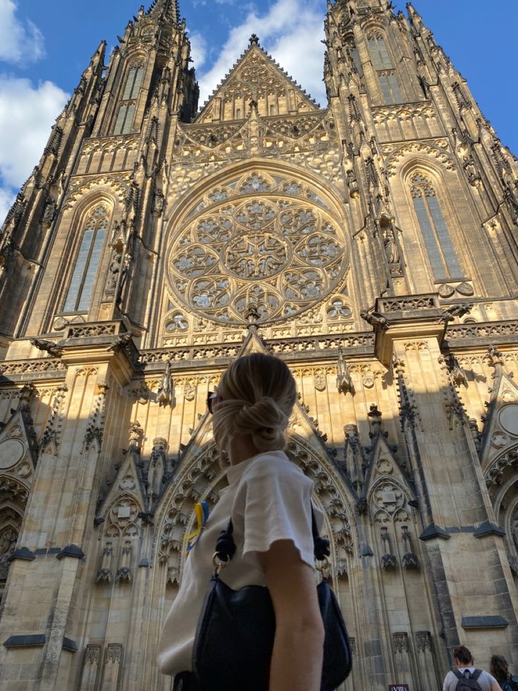 a woman standing in front of a large cathedral