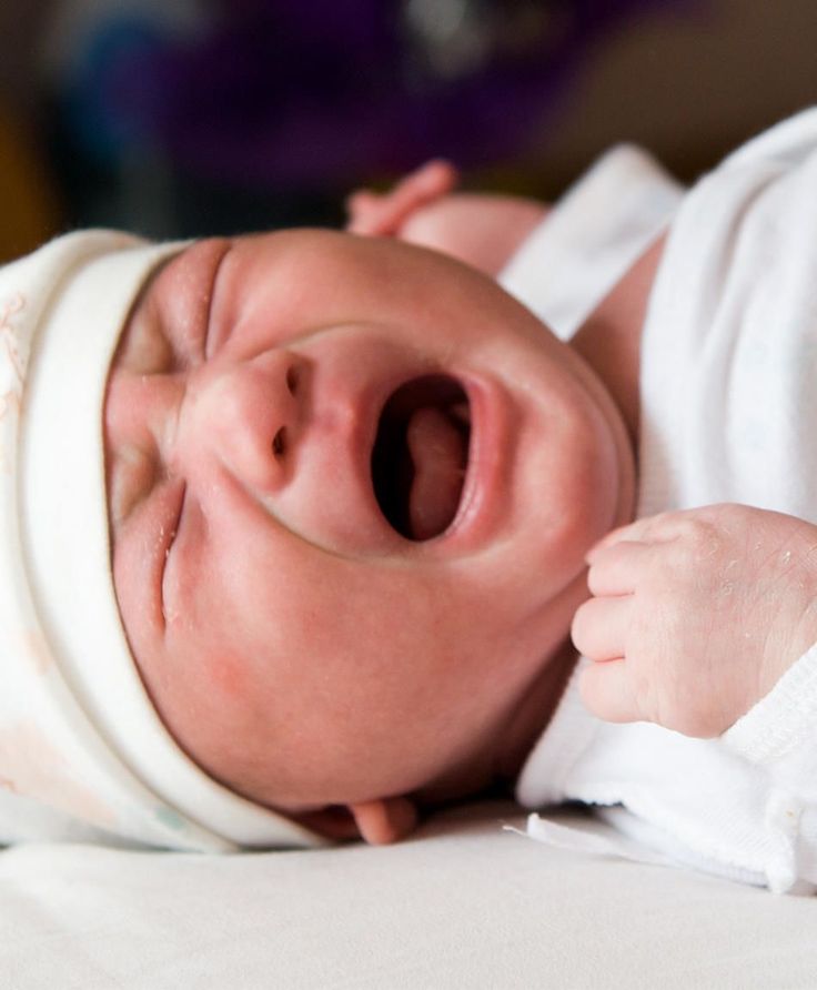 a baby is laying down with its mouth open