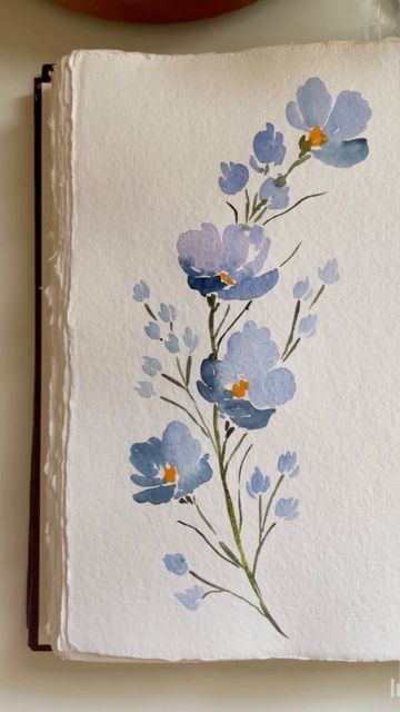 a painting of blue flowers on white paper