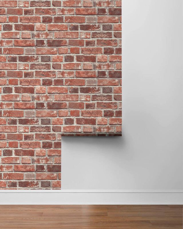 an empty room with a brick wall and wooden floor