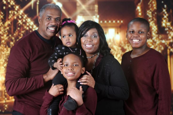 a family posing for a photo in front of christmas lights