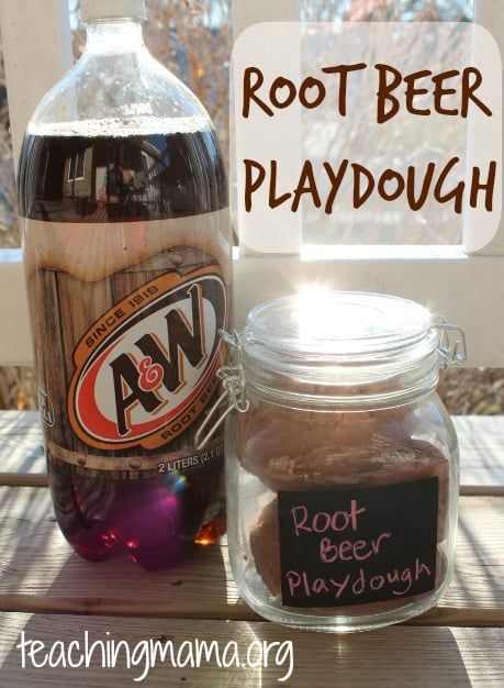 root beer playdough in a glass jar next to a bottle of root beer