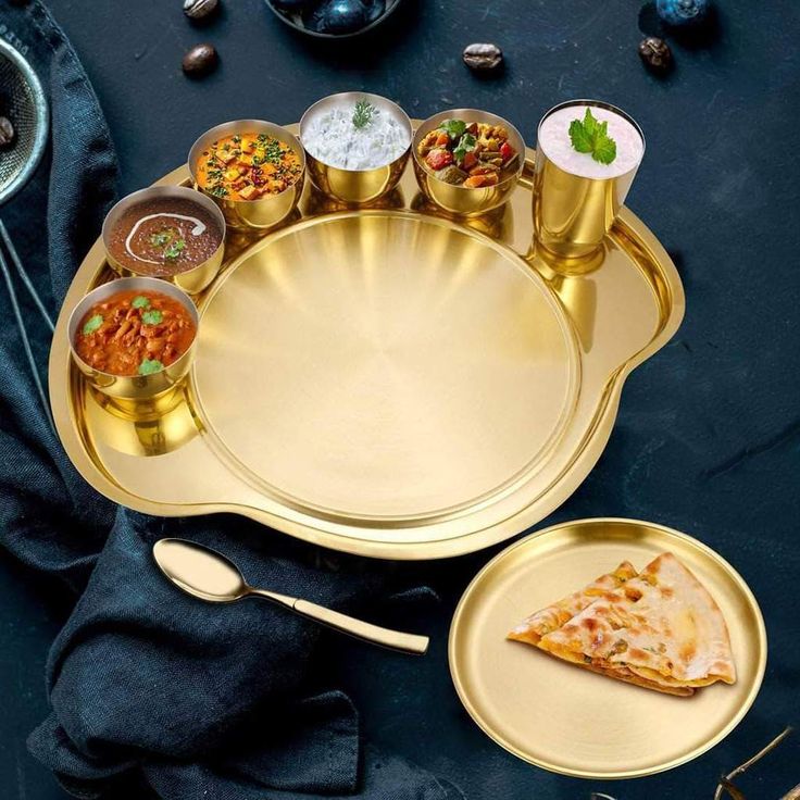 there is a tray with food on it next to two cups and spoons,