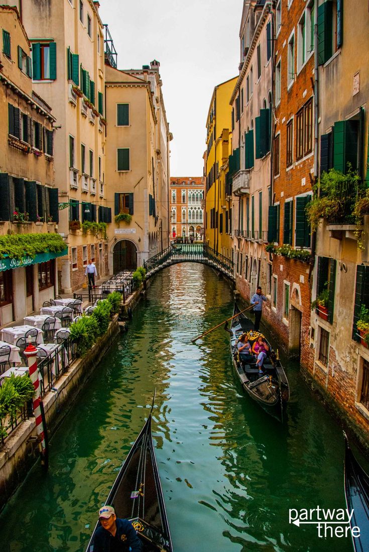 two gondolas in the middle of a narrow canal