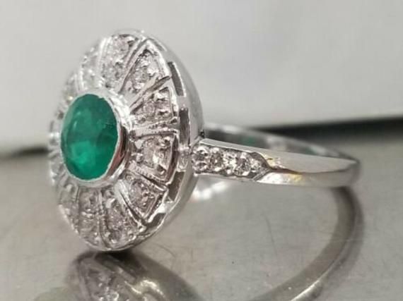 Vintage natural emerald in 14k white gold ring circ 1940's center natural green emerald in round shape weight 0.92ct SIZE 5.8mm side set natural diamonds weight 0.50ct H-SI1 lively,sparkly stone.clean. Ring size 6.5 This tremendous old vintage ring is in a very good condition. Appraisal available Retail value $4,750 net Vintage Green Emerald Ring Gia Certified, Classic Round Emerald Ring With Halo Setting, Silver Gia Certified Round Emerald Ring, Classic Round Emerald Ring With Halo Design, Platinum Emerald Ring With Center Stone, Art Deco Green Diamond Ring, Classic Green Diamond Round Ring, Classic Round Green Diamond Ring, Classic Green Diamond Ring