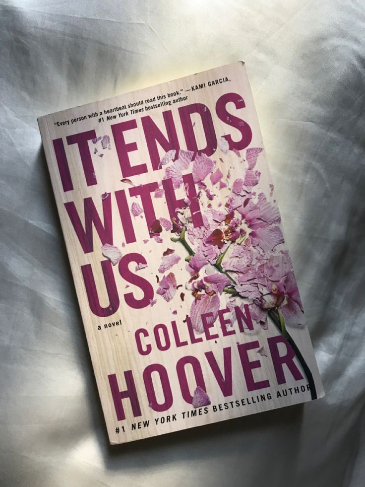 the book it ends with us by colleen hoover is laying on a bed