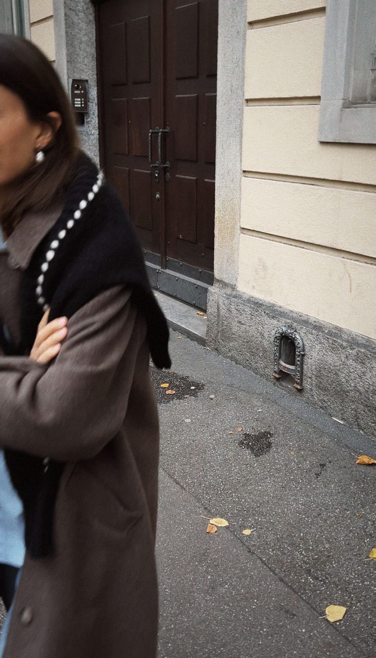 a woman is walking down the street with her hand on her shoulder while carrying a baby