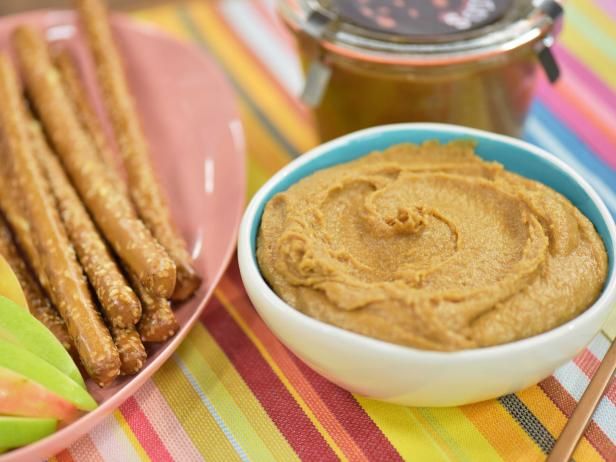 a bowl of hummus next to a plate of churros