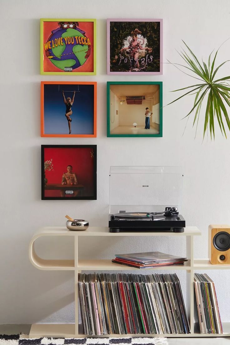 a record player sitting on top of a table next to a wall mounted with records