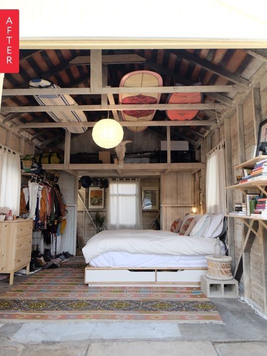 a bed sitting inside of a wooden room next to a closet filled with books and other items