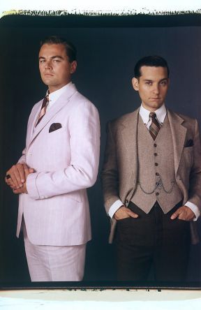 two men in suits standing next to each other with their hands on their hipss