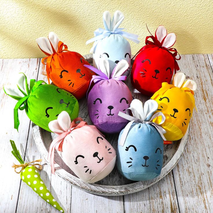 a basket filled with colorful stuffed animals on top of a wooden table next to a wall