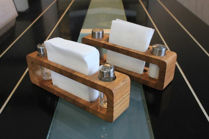 two wooden trays with napkins and salt and pepper shakers sitting on a counter