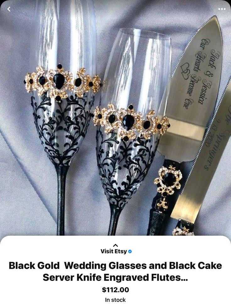 three wine glasses with black and gold decorations on them are next to a silver knife