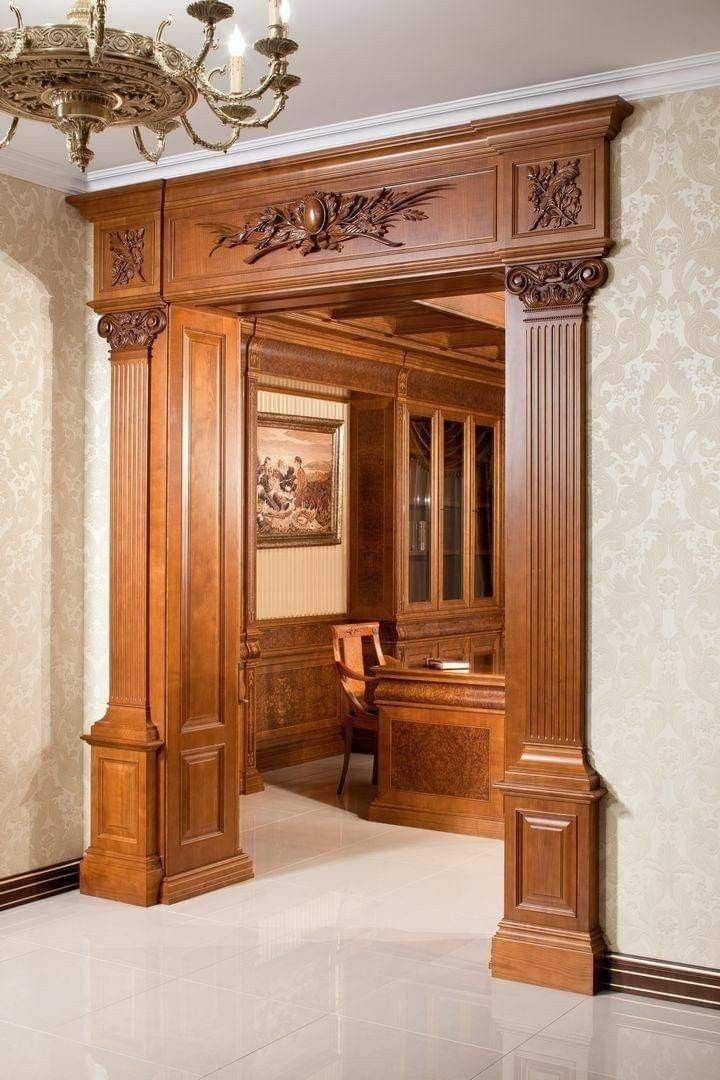 an elegant wooden room with chandelier and desk in it's centerpiece