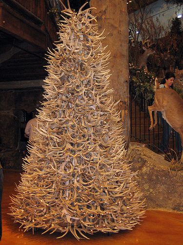 an antler's head is on top of a fake christmas tree at the zoo