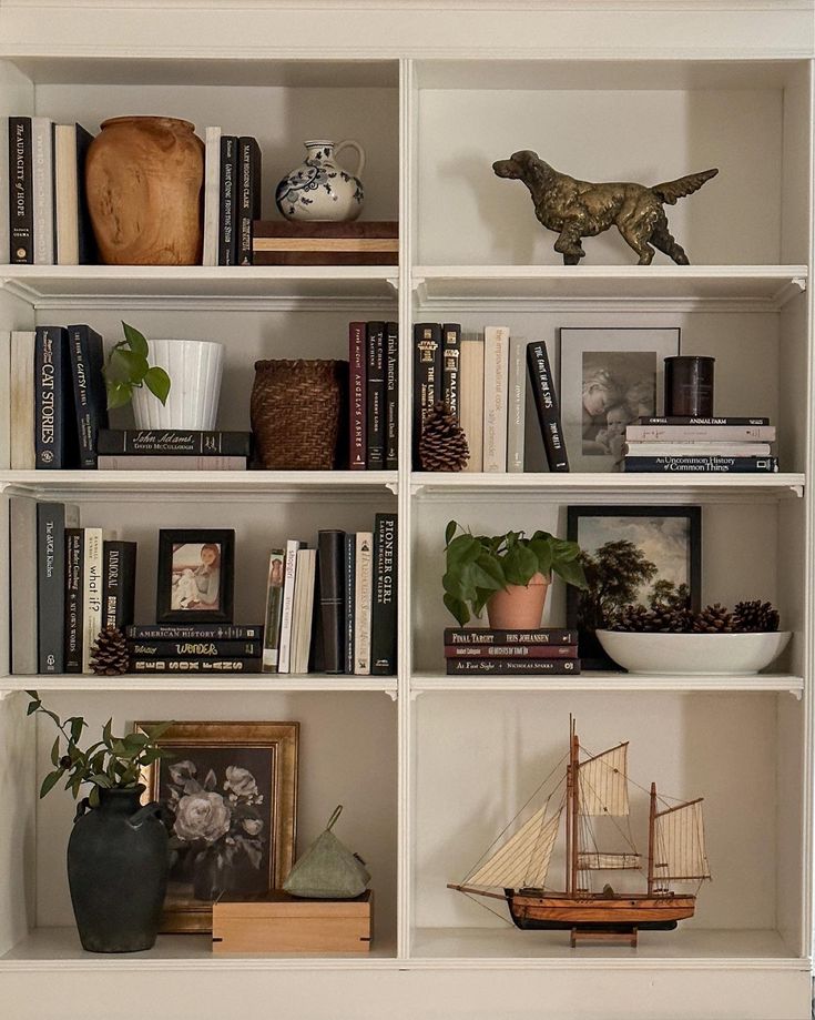 a book shelf with books, vases and other decorative items on top of it