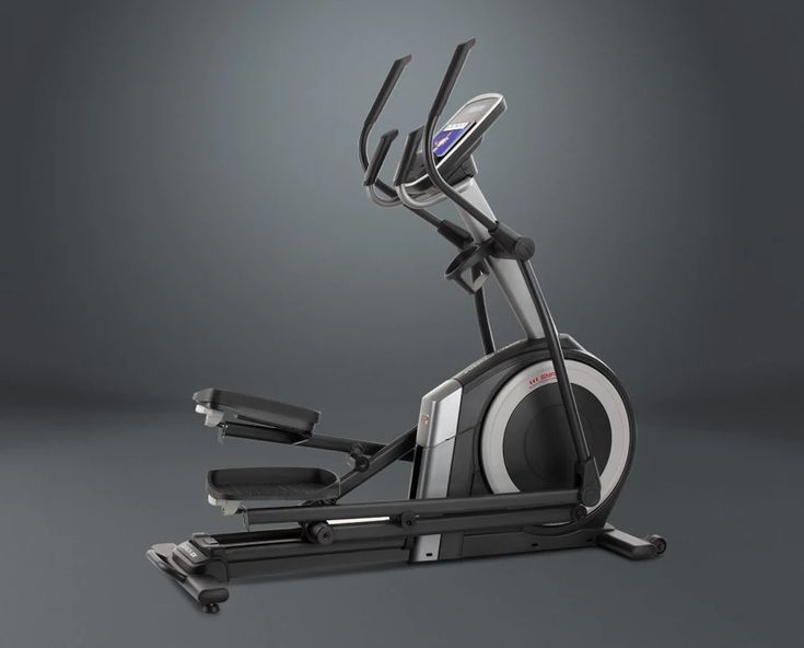 an exercise bike is shown with the seat up and handlebars down, in front of a gray background