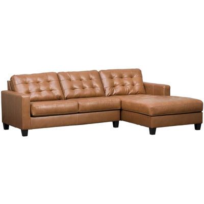 a brown leather sectional sofa sitting on top of a white floor