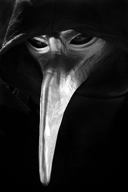 a black and white photo of a bird wearing a hood