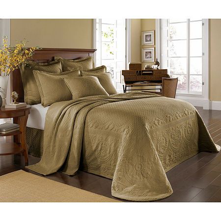 a bed covered in a brown bedspread and pillows