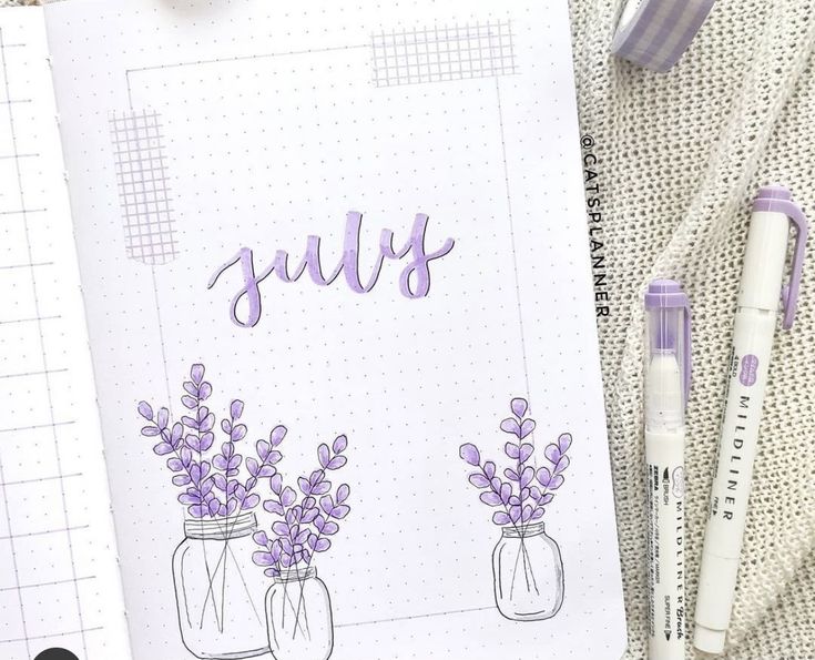 an open notebook with purple flowers and the word july written in cursive writing