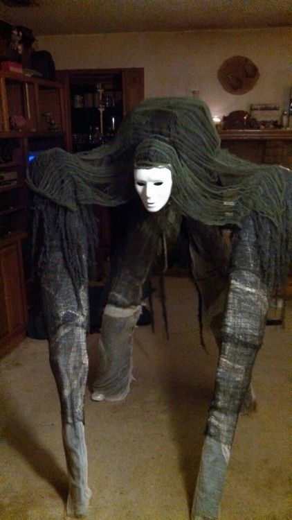 a mannequin with long hair and boots in a living room next to a table