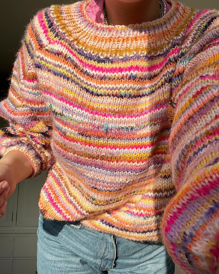 a close up of a person wearing a colorful sweater