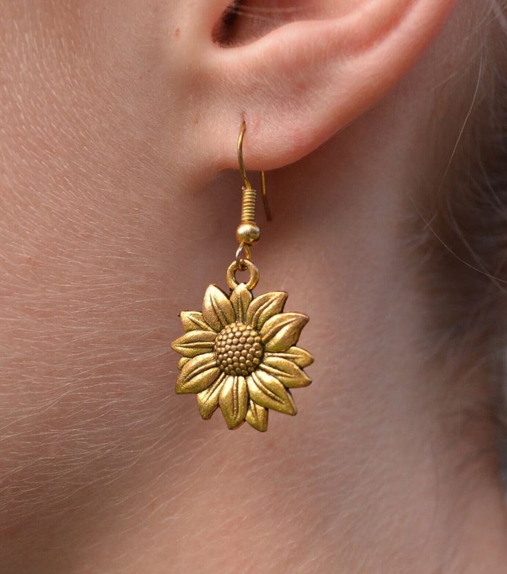 New Handmade Sunflower Dangle Earrings Sunflowers  yearn for light, symbolizing health, happiness, vitality, pursuing a positive life, and always have a positive attitude. Sunflower represents the courage to pursue the happiness you want. ~ 14k gold over sterling silver ear hooks  ~ Drop length 1.5 inches ~ Gold tone stainless steel Sunflower charm ~ Hypoallergenic  ♡ Also available in silver in my Etsy store. ☆I ship daily Monday-Saturday☆ Gift Packaging & Messages: Your item will be lovingly p Brass Flower Earrings, Brass Flower Earrings For Gift, Gold Flower Earrings With Ear Wire, Brass Flower Earrings With Ear Wire, Adjustable Gold Flower Earrings, Flower Shaped Brass Jewelry With Matching Earrings, Brass Flower Earrings With Charm As Gift, Gold Flower Single Earring Jewelry, Single Gold Flower Earring