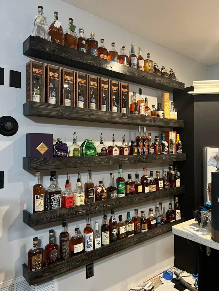 the shelves are filled with liquor bottles and other alcohol on it's side wall